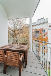 a patio with a wooden table and chairs on a balcony at easy flat Molino in Vienna