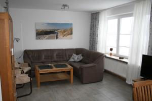 ein Wohnzimmer mit einem braunen Sofa und einem Tisch in der Unterkunft Frey - Ferienhaus über zwei Etagen mit Terrasse in Eggebek