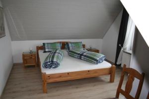 ein Schlafzimmer mit einem Bett mit vier Kissen darauf in der Unterkunft Frey - Ferienhaus über zwei Etagen mit Terrasse in Eggebek + 3 Fotos