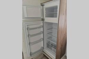 einem leeren Kühlschrank mit offener Tür in einem Zimmer in der Unterkunft Ingrid`s Ferienwohnung in Röthenbach an der Pegnitz