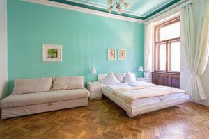 ein blaues Schlafzimmer mit einem Bett und einem Sofa in der Unterkunft For celebrations spacious 3BDR apartment with balcony in Prag