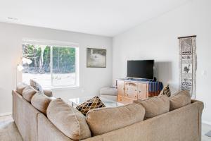 ein Wohnzimmer mit einem Sofa und einem TV in der Unterkunft Sea La Vie in Pacific Beach