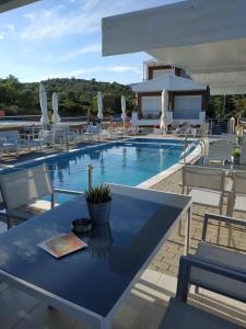 a swimming pool with a blue table and chairs at De Sol in Limenaria