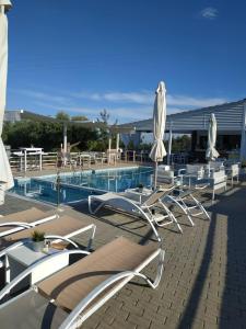 a group of chairs and umbrellas next to a swimming pool at De Sol in Limenaria