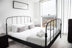 a bedroom with a black bed with white pillows at City Stay Apartments - Hub in Milton Keynes
