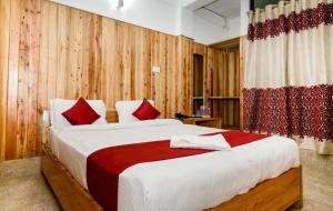 a bedroom with a large bed with red pillows at Silver Brook Resort Mylliem Upper Shillong in Shillong