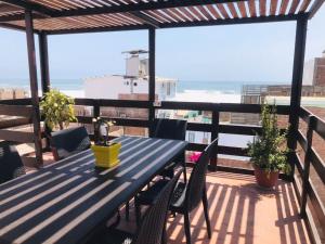 a blue table and chairs on a balcony with the ocean at Casa de Playa Arica in Lurín