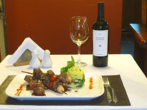 a plate of food and a glass of wine on a table at Village Condo in San Carlos de Bariloche