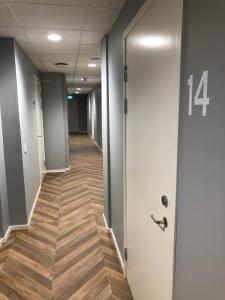 un corridoio di un ufficio con porta e pavimenti in legno di Mini-Hotel Borås Regementet a Borås