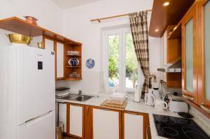 Una cocina con un refrigerador blanco y una ventana. en Villa Gemma, en Mlini 29 fotos más