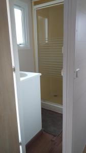 a bathroom with a shower and a window and a door at Mobilhome chez Cathy & Simon in Marseillan