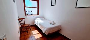 a small bedroom with a bed and a chair at VV Duplex Isla Bonita "by henrypole home" in Los Cancajos +49 photos
