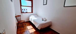 ロス・カンカホスにあるVV Duplex Isla Bonita "by henrypole home"の小さなベッドルーム(ベッド1台、椅子付)