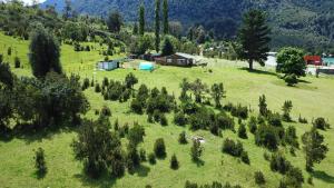 an aerial view of a field with trees and a house at Base Puelo in Cochamó