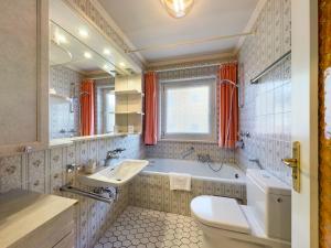 a bathroom with a tub and a sink and a toilet at FeWo Wankblick in Garmisch-Partenkirchen