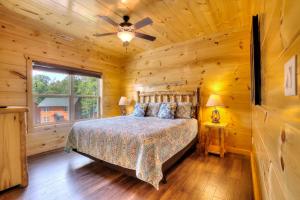 a bedroom with a bed and a ceiling fan at Luxury 5bed/6ba Cabin: Theater, Pool Room, Hottub! in Gatlinburg