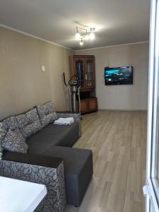 sala de estar con sofá y TV de pantalla plana en Apartment with balcony on Peremohy Avenue 43, en Cherníhiv