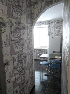 a dining room with a table and a wall covered in drawings at Apartment with balcony on Peremohy Avenue 43 in Chernihiv