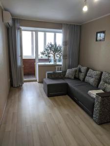 ein Wohnzimmer mit einem Sofa und einem großen Fenster in der Unterkunft Apartment with balcony on Peremohy Avenue 43 in Tschernihiw