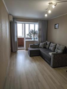 ein Wohnzimmer mit einem Sofa und einem großen Fenster in der Unterkunft Apartment with balcony on Peremohy Avenue 43 in Tschernihiw