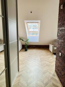 a living room with a vaulted ceiling and a wooden floor at Botanical Manor Apartment in Kaunas