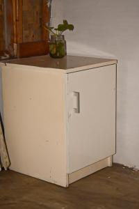a white cabinet with a plant on top of it at Paddies Homestay New in Cipaku-gede
