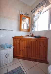 baño con lavabo, espejo y ventana en Schelde Apartment, en Jeffreys Bay