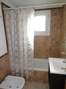 Un baño con cortina de ducha y lavabo. en Departamento Mariano Moreno, en San Martín de los Andes