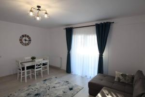 White Apartment Gura Humorului, Bucovina, Voronet في جورا هومورولوي: غرفة معيشة مع أريكة وطاولة