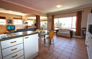 a kitchen and living room with a table and a couch at Schelde Apartment in Jeffreys Bay