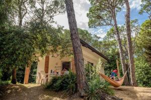 a couple of hammocks in front of a house at Arco Bungalow in Eraclea Mare