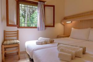 a bedroom with two beds and a window at Arco Bungalow in Eraclea Mare