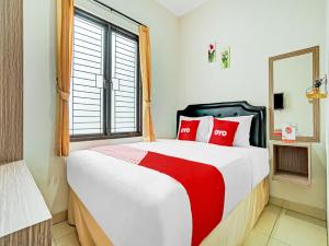 a bedroom with a large bed with red pillows at OYO Life 90211 I-sidji Inn in Karawang