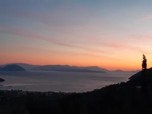 a sunset over a body of water with mountains at Vasiliki View in Áyios Pétros