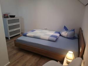 una piccola camera da letto con un letto e un comodino di FeWo Rügshofen a Gerolzhofen