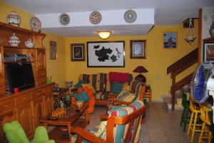 a living room filled with lots of chairs and a tv at Casa Mariluz in Agaete