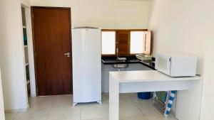 a kitchen with a white counter and a microwave at Condomínio Villa dos Corais in Maragogi