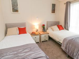 a bedroom with two beds and a table with a window at Huckleberry in Saltburn-by-the-Sea