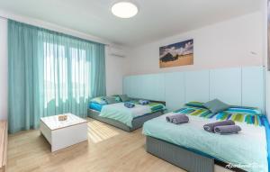 sypialnia z 2 łóżkami i stołem w obiekcie Apartmani Nena i Ilka w Puli