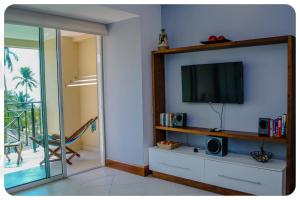 a living room with a flat screen tv on a wall at "El Pajaro Carpintero" in Ixtapa