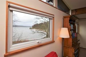 una ventana en una habitación con vistas al agua en Oystershell Lodge, en Otter Ferry