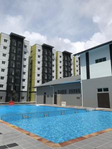 a large swimming pool in front of some buildings at Homestay Musafir Apartment Seri Iskandar 2.0 in Seri Iskandar