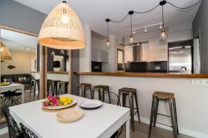 a kitchen with a white table with a bowl of fruit on it at Sitges Spaces Deluxe Centre Apartment in Sitges