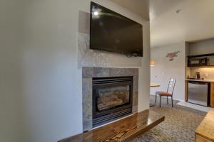 a living room with a fireplace with a flat screen tv on the wall at The Gonzo Inn in Moab
