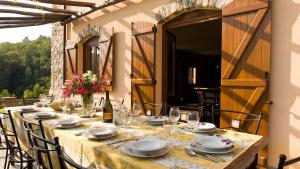stół z talerzami i kieliszkami oraz butelkę wina w obiekcie VILLA ARBEIO 8&6, Emma Villas w mieście Varese Ligure