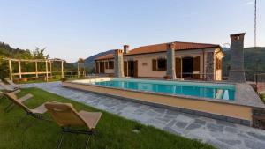 dom z basenem i dwoma krzesłami na dziedzińcu w obiekcie VILLA ARBEIO 8&6, Emma Villas w mieście Varese Ligure