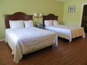 ein Hotelzimmer mit 2 Betten mit weißer Bettwäsche in der Unterkunft Matanzas Inn in Fort Myers Beach