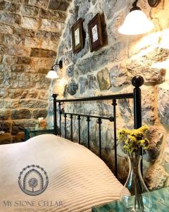 ein Schlafzimmer mit einem Bett und einer Steinmauer in der Unterkunft Stone Cellars in Douma