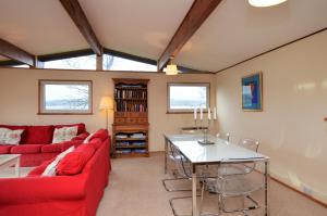 a living room with a red couch and a table at Oystershell Lodge in Otter Ferry