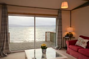- un salon avec une grande fenêtre donnant sur l'océan dans l'établissement Oystershell Lodge, à Otter Ferry